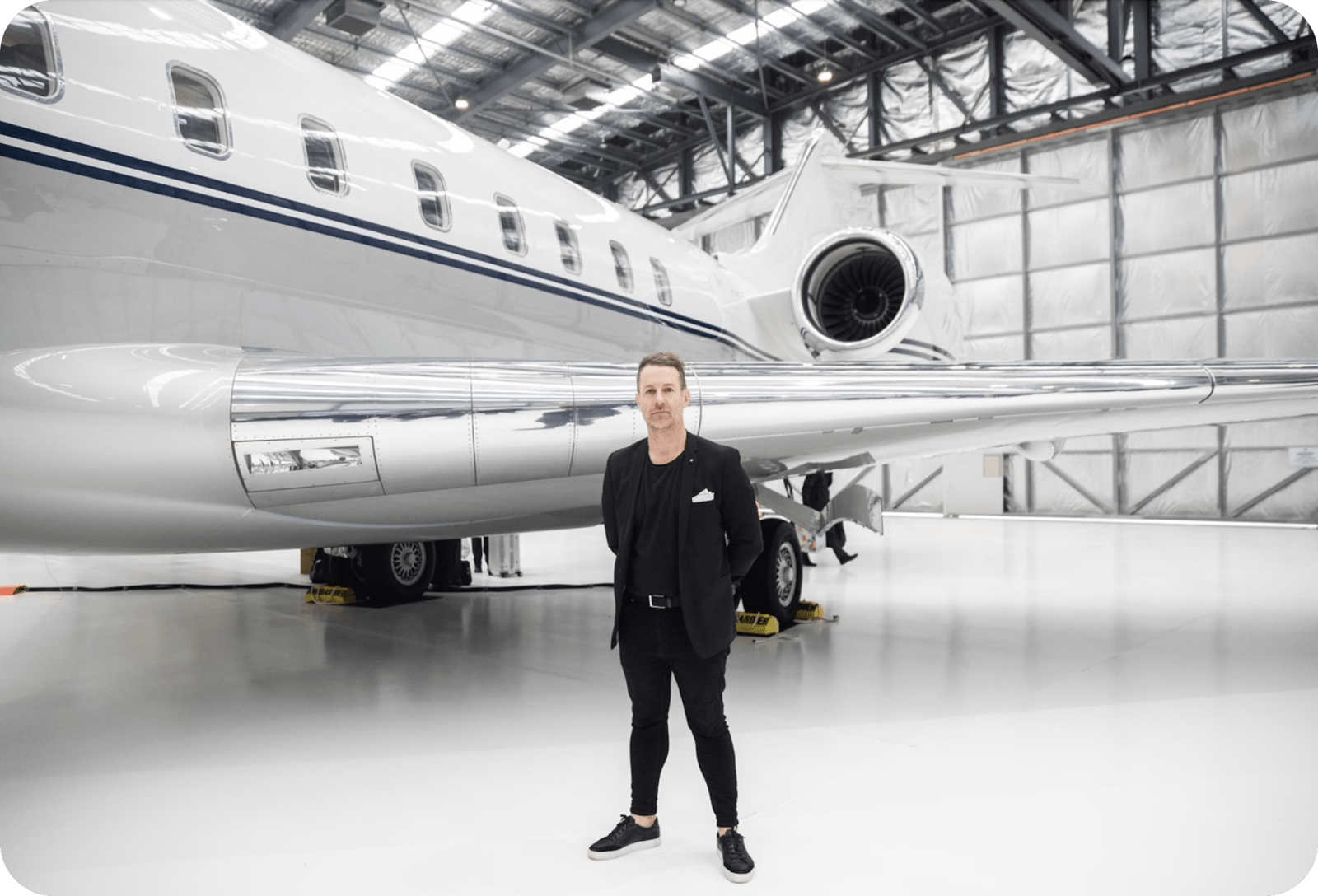 Event planner male standing in front of private jet