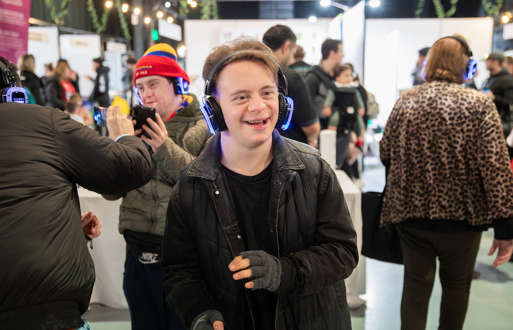 Young Man Smiling at Silent Disco during Benevolent Society Community Event